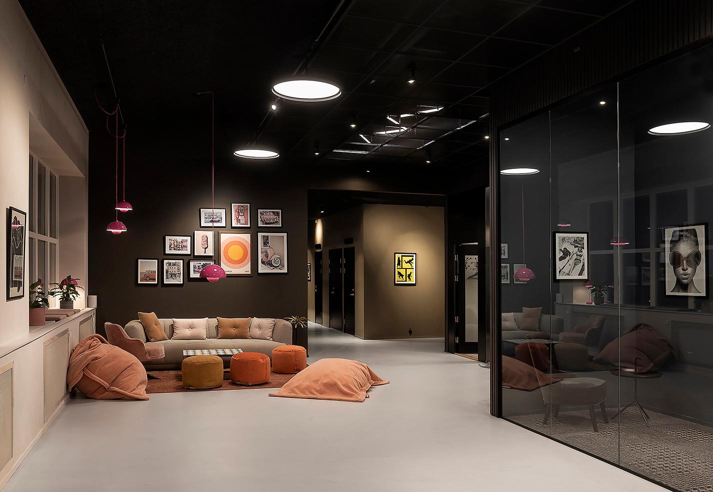 Lounge med soffa och sittpuffar på kontorsvåningen