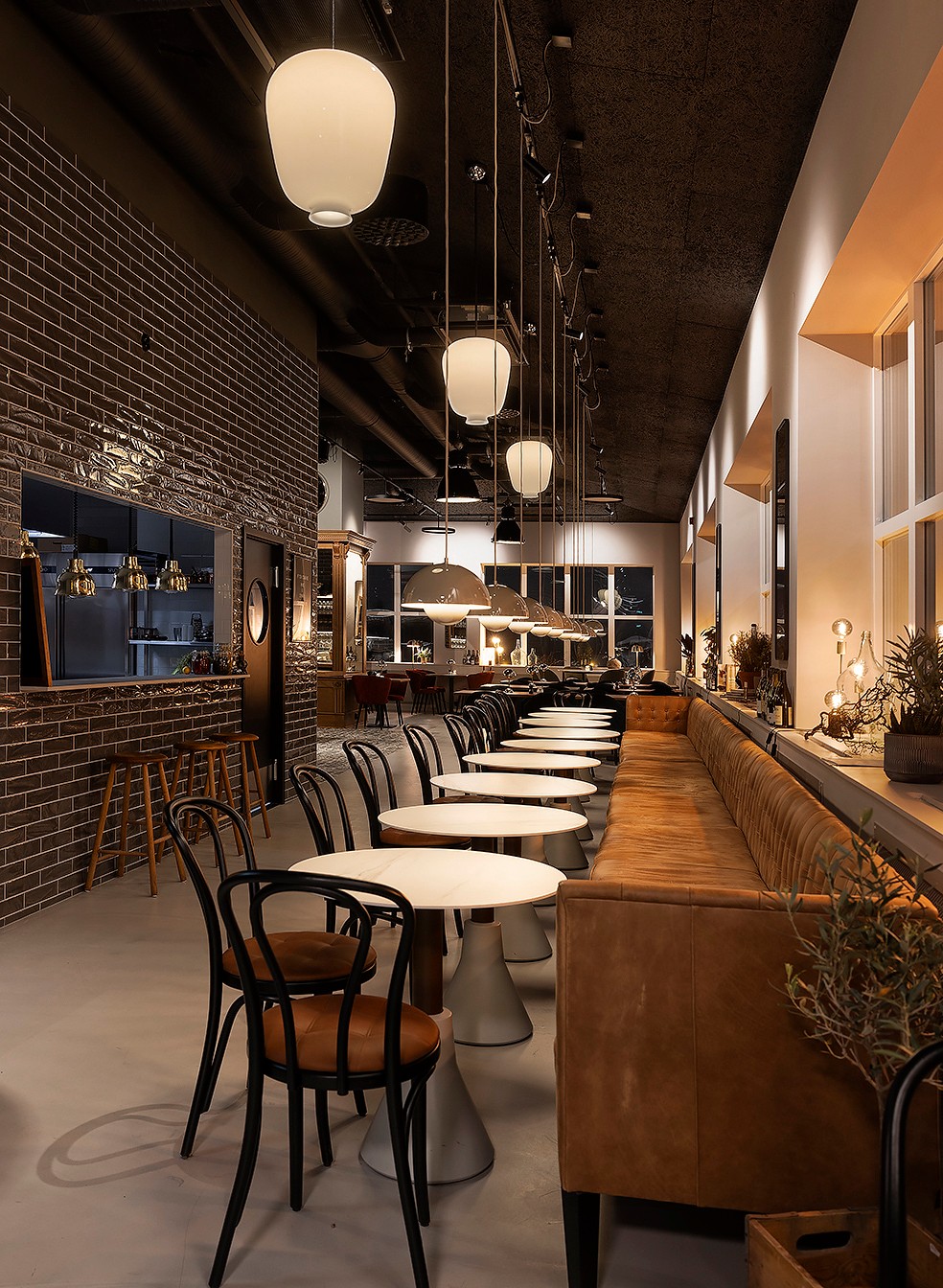 Hygge's restaurant with a brick wall, pendant lights, and a leather banquette